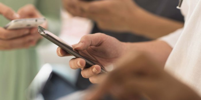 man with phone in hand working on improving social media customer engagement
