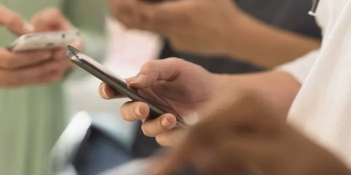 man with phone in hand working on improving social media customer engagement