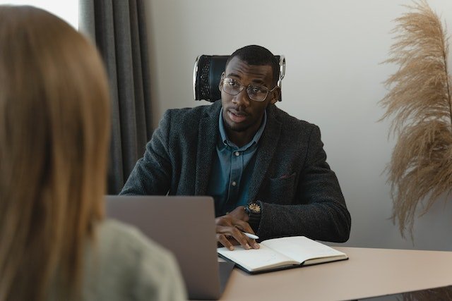 man giving negative feedback to a woman from across a desk